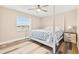 Bright bedroom featuring coastal-themed decor, wood floors, a ceiling fan and a window with a canal view at 3505 Seaway Dr, New Port Richey, FL 34652