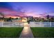 Sunset view of canal-front property with a walkway leading to a private dock and boat slip at 3505 Seaway Dr, New Port Richey, FL 34652