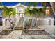 Home featuring a landscaped front entrance with palm trees, stone accents, and a multi-car garage at 3505 Seaway Dr, New Port Richey, FL 34652