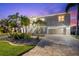 Charming two-story waterfront home with a two-car garage, lush palm trees, and inviting front entrance at 3505 Seaway Dr, New Port Richey, FL 34652