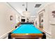 Open-concept game room features a pristine pool table with dark wood trim and view into the living room at 3505 Seaway Dr, New Port Richey, FL 34652