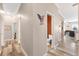 Hallway with wood floors, open bathroom featuring orange wall and patriotic wall art at 3505 Seaway Dr, New Port Richey, FL 34652