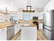 Bright kitchen featuring stainless appliances, white cabinets, and a center island at 3505 Seaway Dr, New Port Richey, FL 34652