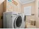 Laundry room featuring washer and dryer, storage cabinets, window with plantation shutters at 3505 Seaway Dr, New Port Richey, FL 34652