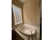 Luxurious soaking tub with a decorative tile surround and a glass block window at 446 Noble Faire Dr, Sun City Center, FL 33573