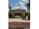Elegant community entrance with lush landscaping, palm trees, and a decorative sign at 446 Noble Faire Dr, Sun City Center, FL 33573