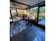 Enclosed patio with slate floors featuring multiple sitting areas overlooking the backyard at 4504 Cabbage Palm Dr, Valrico, FL 33596