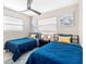 Shared bedroom with two twin beds, stylish decor, and a ceiling fan at 5519 Homewood Dr, Sarasota, FL 34232