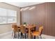 Stylish dining room with modern light fixture, slat wall accent, and wood dining table with leather chairs at 5519 Homewood Dr, Sarasota, FL 34232