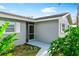 A single story home's entrance with a tiled porch, walkway, fresh paint, and lush tropical landscaping at 5519 Homewood Dr, Sarasota, FL 34232
