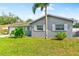 Close up view of a single story home's lush green front yard, palm tree, landscaping, and paved walkway at 5519 Homewood Dr, Sarasota, FL 34232