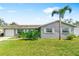 Well kept single story home with a driveway, large grassy yard, a palm tree, and fresh landscaping on a sunny day at 5519 Homewood Dr, Sarasota, FL 34232