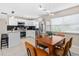 Open kitchen and dining area featuring stainless steel appliances, black backsplash, and a modern light fixture at 5519 Homewood Dr, Sarasota, FL 34232