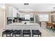 Kitchen with island seating, stainless appliances, white cabinets, black backsplash, and view into the dining area at 5519 Homewood Dr, Sarasota, FL 34232