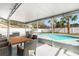Covered patio with wicker furniture, dining table, and view of the pool and backyard oasis at 5519 Homewood Dr, Sarasota, FL 34232
