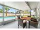 A covered patio includes wicker furniture and a dining table with a view of the pool and grassy backyard at 5519 Homewood Dr, Sarasota, FL 34232