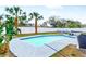 Backyard pool with turquoise water, surrounded by concrete and palm trees, enclosed with a white privacy fence at 5519 Homewood Dr, Sarasota, FL 34232