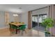 Elegant dining area with a wooden table, green velvet chairs, and sliding glass doors leading to an outdoor space at 5591 15Th N Ave, St Petersburg, FL 33710