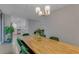 Cozy dining area with a wooden table, green chairs, a modern chandelier, and easy access to the updated kitchen at 5591 15Th N Ave, St Petersburg, FL 33710