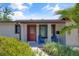 Inviting front entrance with a decorative red door, complemented by blue chairs and lush landscaping, creating a warm welcome at 5591 15Th N Ave, St Petersburg, FL 33710