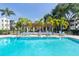 Pool area with palm trees and chairs with a pavilion in the background, resort-style living at 5980 Terrace Park N Dr # 214, St Petersburg, FL 33709