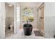 Elegant bathroom featuring a freestanding tub, glass-enclosed shower, and marble tile at 6130 Japonica Ct, New Port Richey, FL 34655