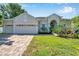 Charming single-story home with a three-car garage, paver driveway, and manicured landscaping at 6130 Japonica Ct, New Port Richey, FL 34655