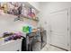 Functional laundry room with washer, dryer, and storage shelving at 6130 Japonica Ct, New Port Richey, FL 34655