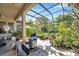 Screened-in patio with a variety of plants, cookware, and outdoor furniture at 6130 Japonica Ct, New Port Richey, FL 34655