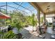 Enclosed patio with lots of potted plants and space for entertaining at 6130 Japonica Ct, New Port Richey, FL 34655
