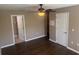 Bedroom with hardwood floors and ceiling fan, leading to a bathroom at 778 Spring Flowers Trl, Brandon, FL 33511