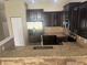 Well-lit kitchen with dark cabinetry, stainless steel appliances, and granite countertops at 778 Spring Flowers Trl, Brandon, FL 33511
