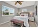 Well-lit bedroom featuring a woven headboard, a bench, and two windows at 7800 Causeway N Blvd, St Petersburg, FL 33707