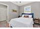Charming bedroom with white bedding, vibrant rug, and natural light from the window at 7800 Causeway N Blvd, St Petersburg, FL 33707