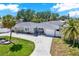 Charming single-story home with a well-manicured lawn, a driveway, and beautiful palm trees in a sunny neighborhood at 7800 Causeway N Blvd, St Petersburg, FL 33707