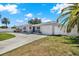 Charming single-story home with a well-maintained yard, blue door, and driveway at 7800 Causeway N Blvd, St Petersburg, FL 33707