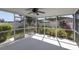 Screened in patio with ceiling fan offers an outdoor living space with garden views at 7933 Floradora Dr, New Port Richey, FL 34654
