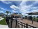 Community playground featuring swings and a shaded area with lush landscaping and a secure black metal fence at 7937 Wheat Stone Dr, Zephyrhills, FL 33540