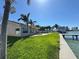 Backyard view showing lush green grass, mature palm trees, patio and waterfront dock at 8053 13Th S Ave, St Petersburg, FL 33707