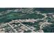 An aerial view showcasing a neighborhood with winding roads and houses surrounded by lush trees, alongside a natural marsh area at 9161 Codel Loop, New Port Richey, FL 34654