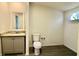 Bathroom with vanity and granite countertop, toilet, gray flooring, and a window at 9161 Codel Loop, New Port Richey, FL 34654