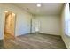 An open bedroom with grey wood-look floors, white walls, and two doors in a simple space at 9161 Codel Loop, New Port Richey, FL 34654