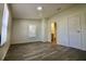 Spacious bedroom with a gray wood-look floor, a window, neutral walls, and a door to the ensuite bathroom at 9161 Codel Loop, New Port Richey, FL 34654
