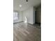 Well-lit bedroom with gray wood-look floors and a view of the doorway to the adjacent room at 9161 Codel Loop, New Port Richey, FL 34654