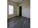 This bedroom has gray wood-look floors, a window with blinds, and two doors at 9161 Codel Loop, New Port Richey, FL 34654