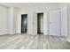 Bedroom has grey wood-look floors and a view to the bathroom and closet at 9161 Codel Loop, New Port Richey, FL 34654