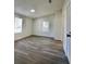 Neutral bedroom features gray wood-look flooring and two windows for natural light at 9161 Codel Loop, New Port Richey, FL 34654