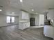 Bright living area with wood-look floors and a view of the modern kitchen at 9161 Codel Loop, New Port Richey, FL 34654