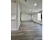 Open-concept living room boasts natural light, fresh paint, and modern grey wood-look flooring at 9161 Codel Loop, New Port Richey, FL 34654