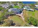 Stunning aerial view of the clubhouse, golf course, pool and tennis courts with a lake backdrop at 9398 N Burnam Dr, Weeki Wachee, FL 34613